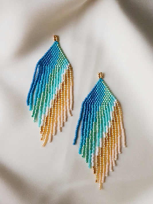 Golden Dawn handmade beaded earrings with cascading strands in blue, green, white, and gold, elegant jewelry inspired by sunrise over golden sands.